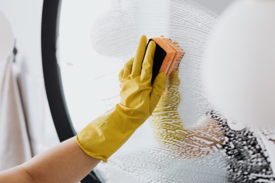 Cleaning person scrubbing a mirror.